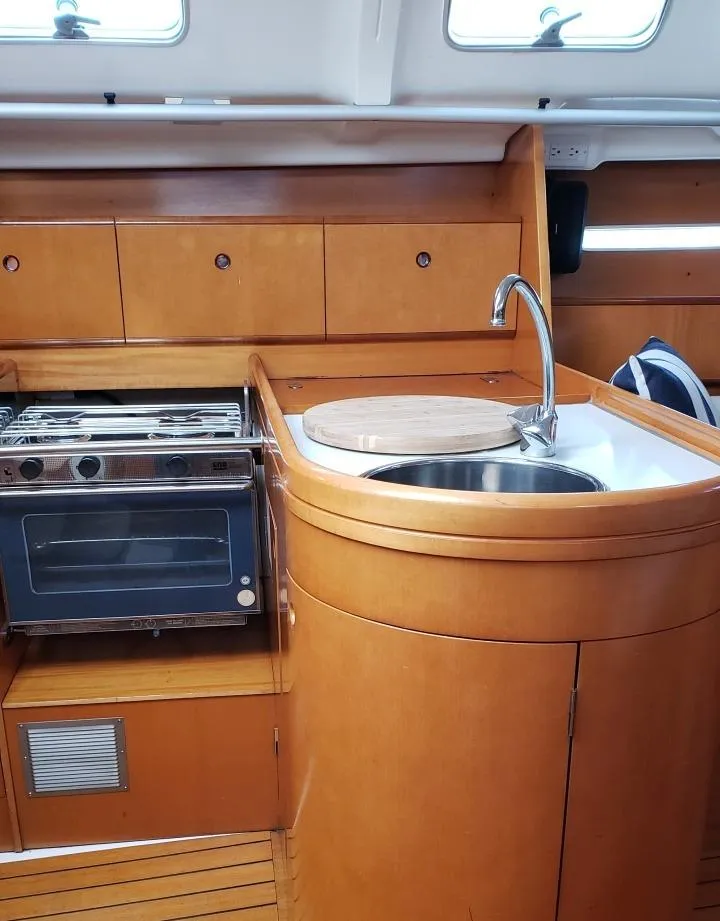 Slide: The Image of 1996 Beneteau First 36s7 yacht kitchen with wood cabinetry, stove, and sink. - 18