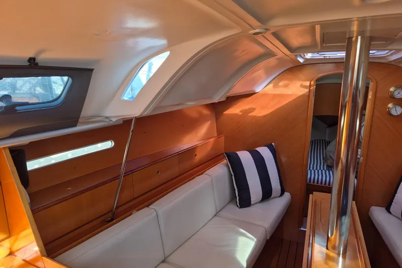 Slide: The Image of Interior of 1996 Beneteau First 36s7 sailboat with cozy seating and striped cushions. - 24