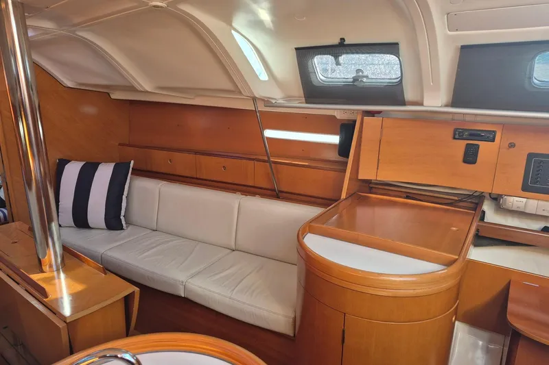 Slide: The Image of Interior of 1996 Beneteau First 36s7 sailboat with wooden cabinetry and white seating. - 25