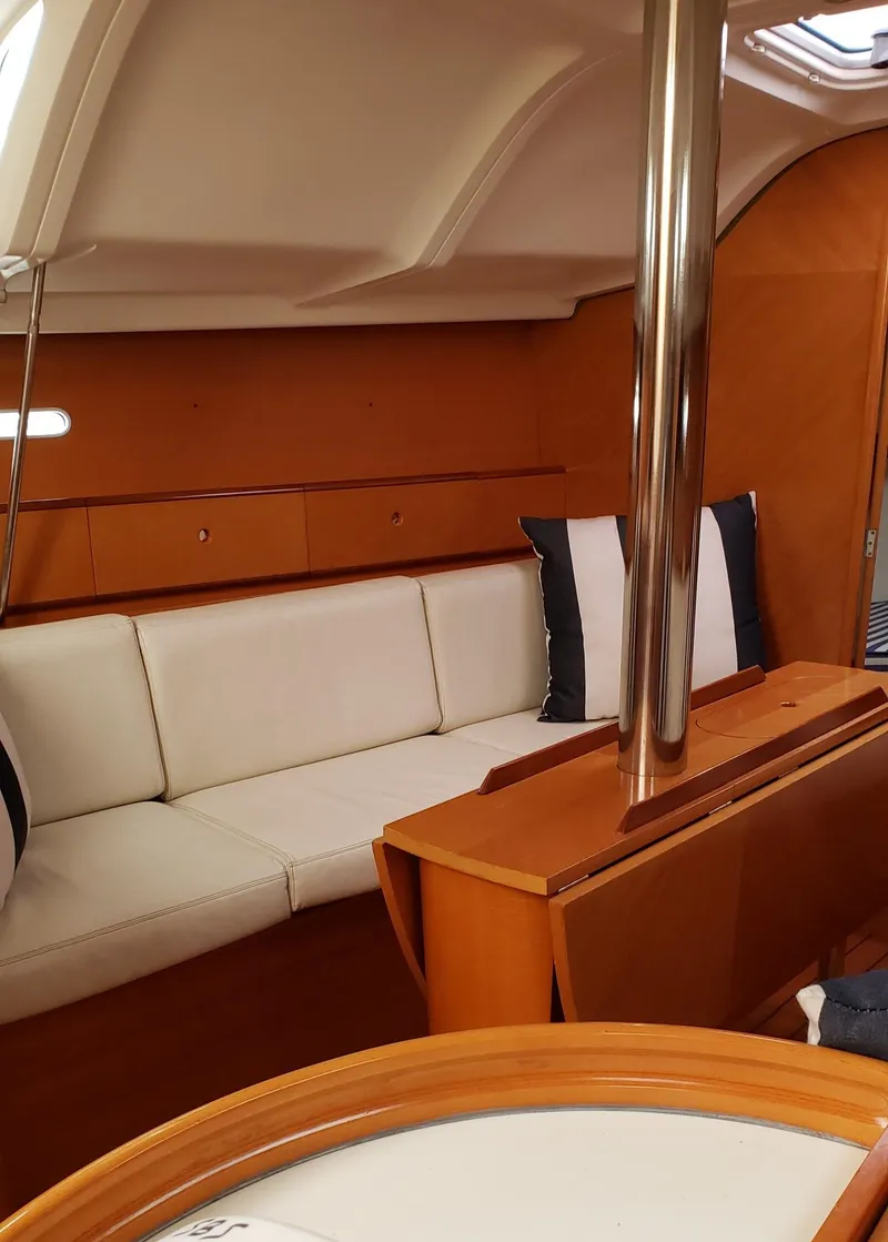Slide: The Image of Interior of 1996 Beneteau First 36s7 yacht with white seating and wooden finishes. - 26
