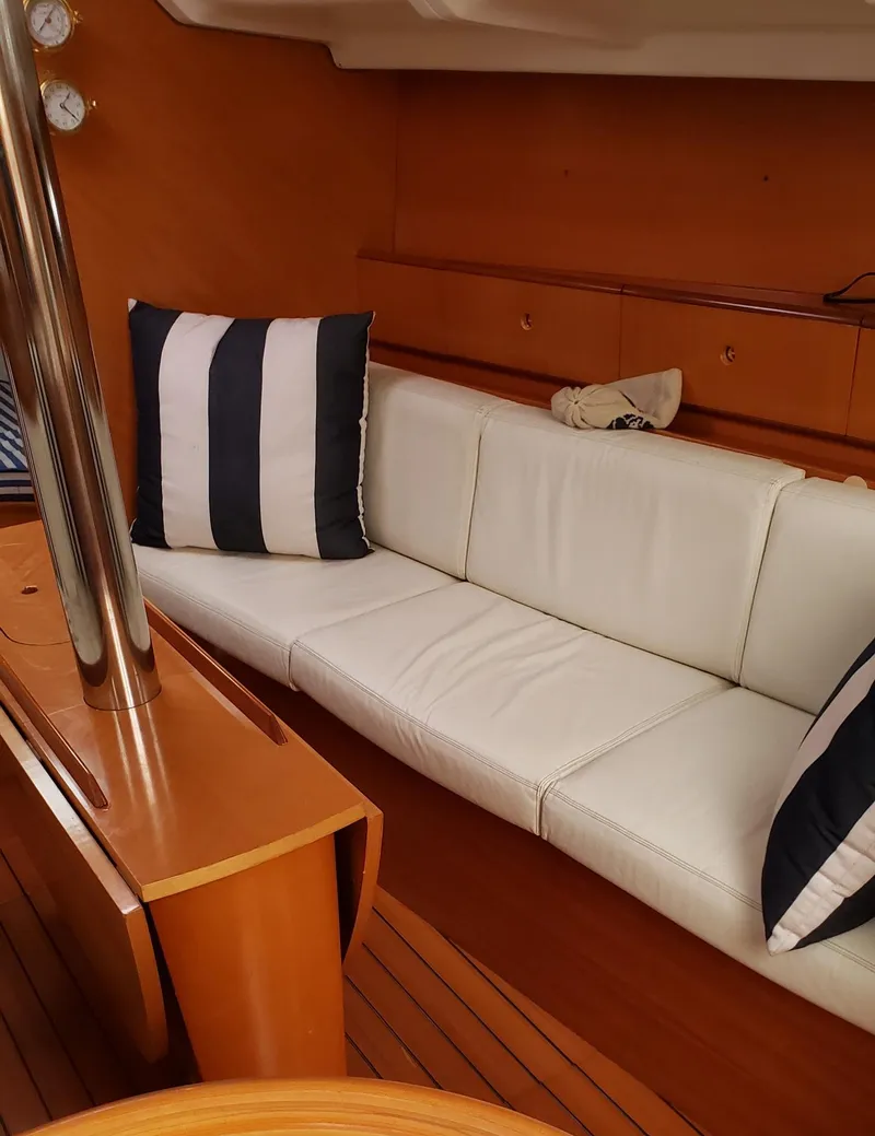 Slide: The Image of Interior of 1996 Beneteau First 36s7 yacht with white seating and striped cushions. - 27