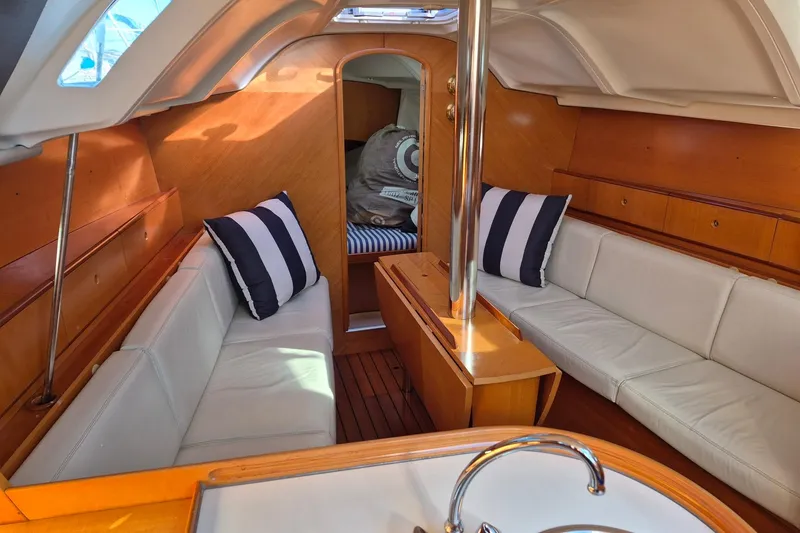 Slide: The Image of Interior of 1996 Beneteau First 36s7 sailboat with cozy seating and striped cushions. - 28