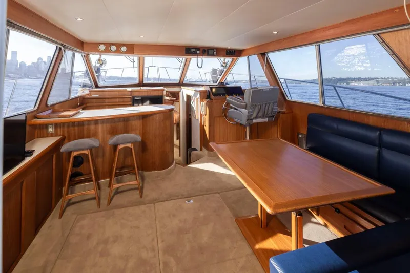 Slide: The Image of 1993 Tollycraft 40 Sport Sedan interior with wood accents, seating, and panoramic windows. - 10