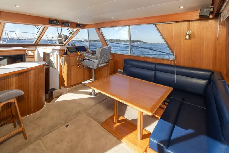 Slide: The Image of Interior of 1993 Tollycraft 40 Sport Sedan with blue seating and wooden table. - 11