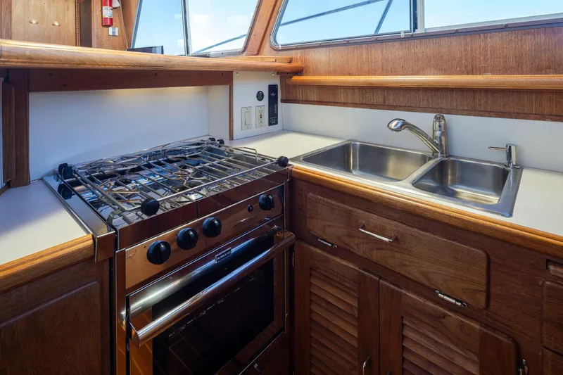 Slide: The Image of 1993 Tollycraft 40 Sport Sedan kitchen with stove, oven, and dual sink. - 17