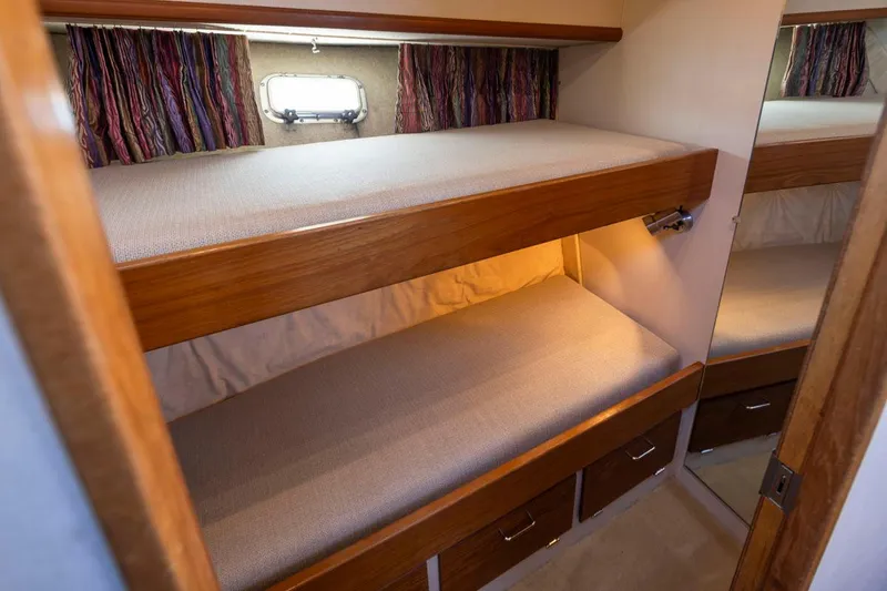 Slide: The Image of 1993 Tollycraft 40 Sport Sedan cabin with wooden bunk beds and storage drawers. - 23