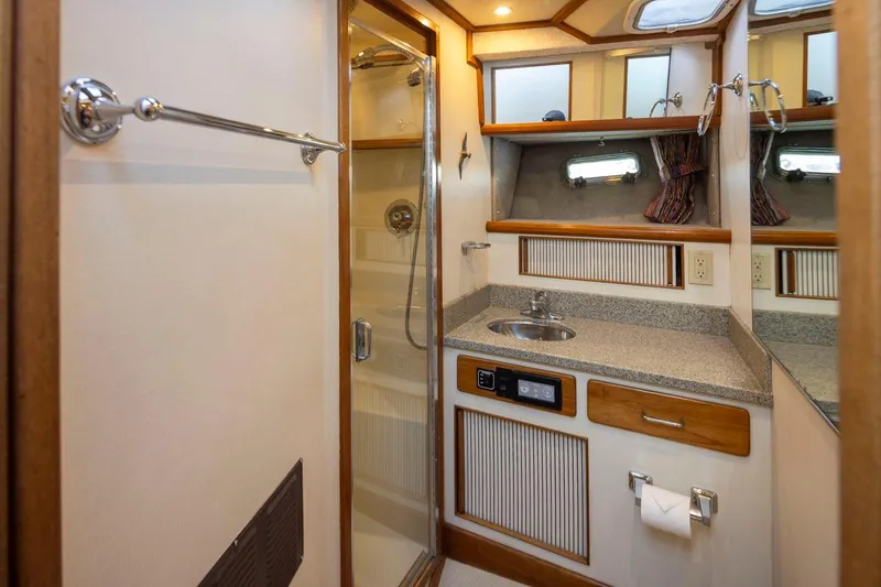 Slide: The Image of 1993 Tollycraft 40 Sport Sedan bathroom with shower, sink, and storage cabinets. - 26