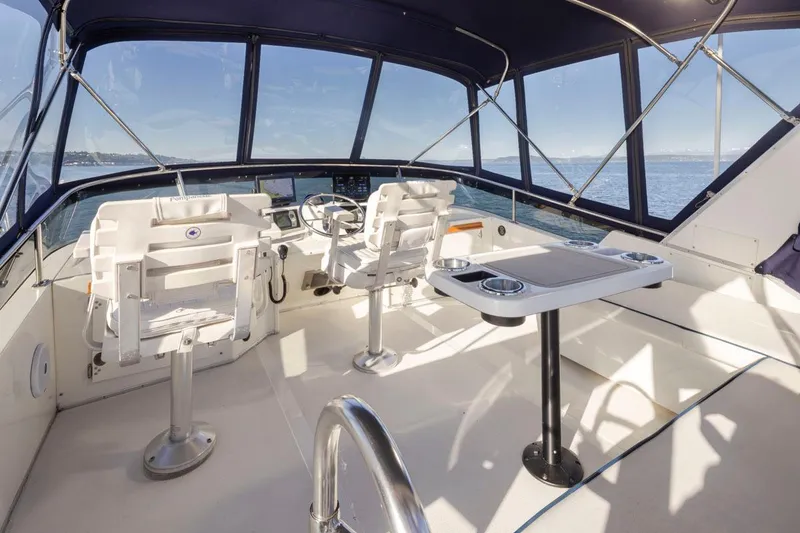 Slide: The Image of 1993 Tollycraft 40 Sport Sedan cockpit with helm, seating, and ocean view. - 28