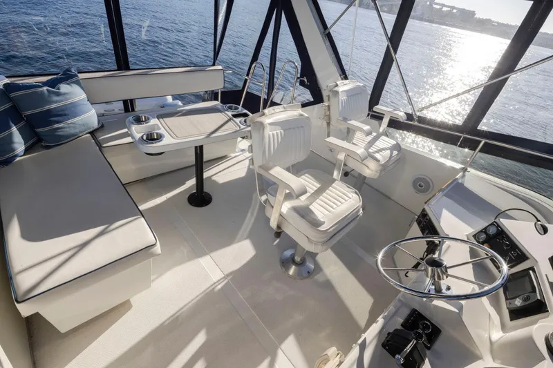 Slide: The Image of 1993 Tollycraft 40 Sport Sedan interior with helm, seating, and ocean view. - 31
