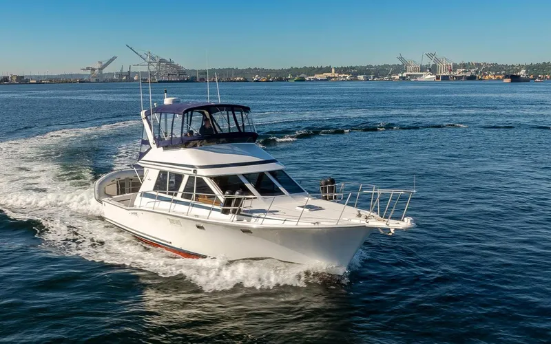 Slide: The Image of 1993 Tollycraft 40 Sport Sedan cruising on open water, with cityscape in the background. - 6