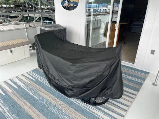 Slide: The Image of 2001 Stardust Cruisers houseboat deck with covered furniture and striped rug. - 11