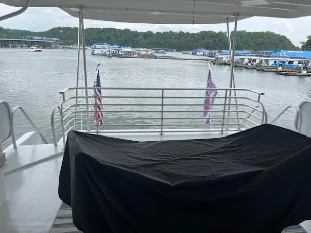 Slide: The Image of 2001 Stardust Cruisers houseboat deck with lake view and American flags. - 14