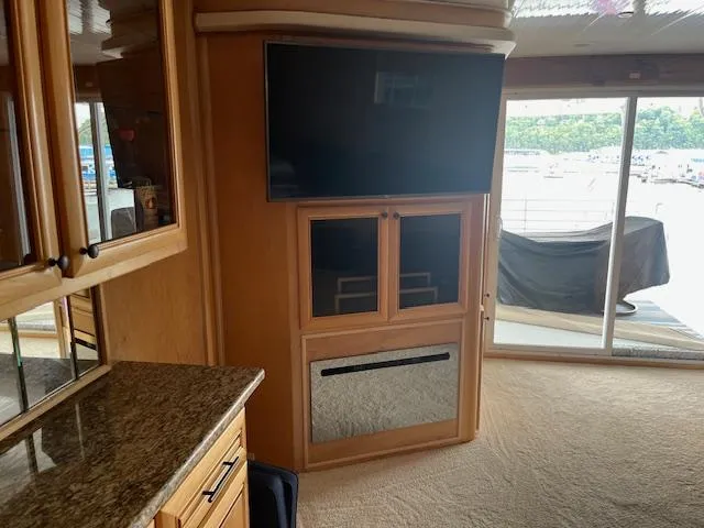Slide: The Image of Interior of 2001 Stardust Cruisers houseboat with TV, cabinets, and sliding glass doors. - 19