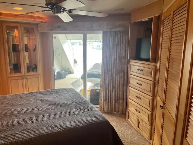 Slide: The Image of Interior of 2001 Stardust Cruisers houseboat bedroom with wooden cabinetry and sliding glass doors. - 25