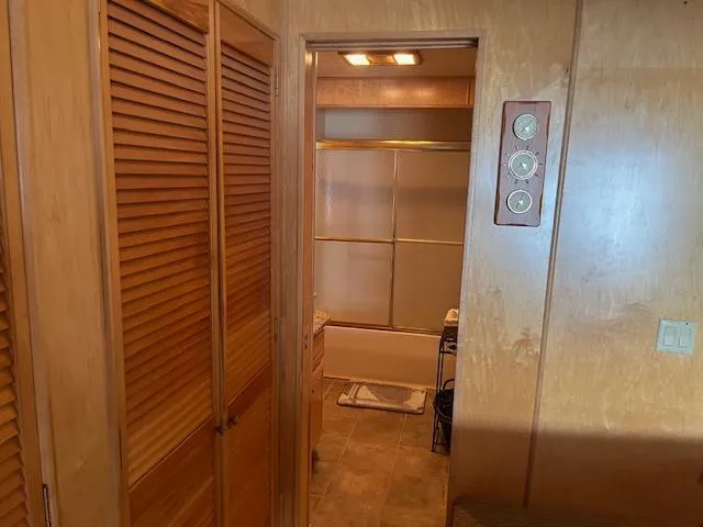 Slide: The Image of Interior of 2001 Stardust Cruisers houseboat featuring wooden paneling and bathroom entrance. - 28