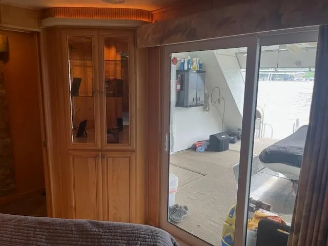 Slide: The Image of Interior view of 2001 Stardust Cruisers houseboat with glass cabinet and sliding door. - 29