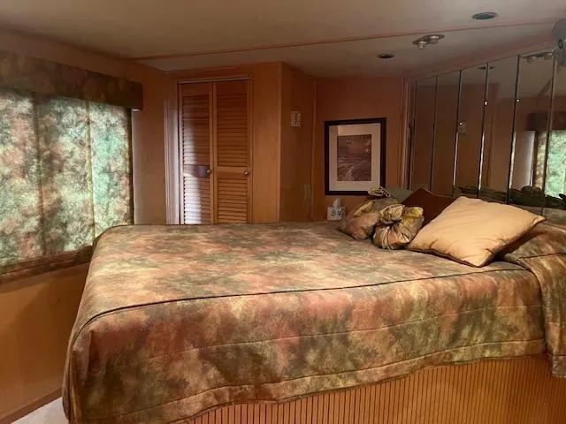 Slide: The Image of Cozy bedroom in 2001 Stardust Cruisers houseboat with patterned bedding and mirrored wall. - 37