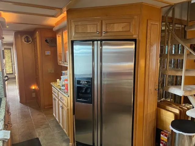 Slide: The Image of 2001 Stardust Cruisers houseboat kitchen with stainless steel fridge and spiral staircase. - 40