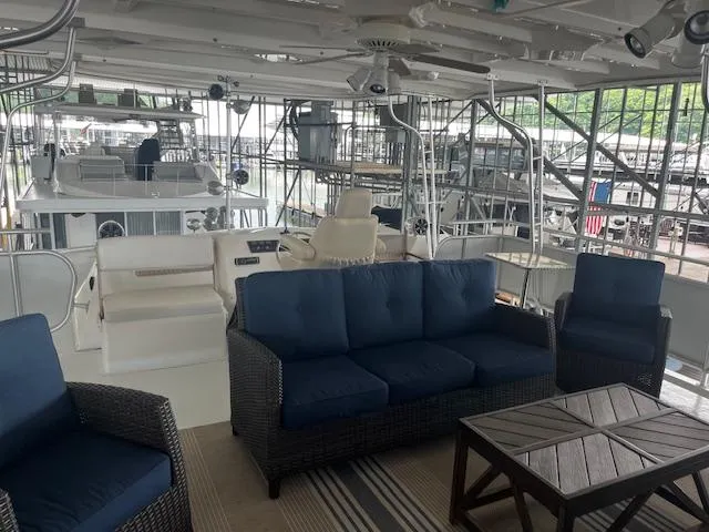 Slide: The Image of 2001 Stardust Cruisers 18 x 103 houseboat interior with blue seating and wooden table. - 9