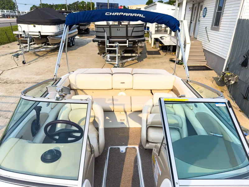 Slide: The Image of 2007 Chaparral 190 SSi boat with beige interior and blue canopy, docked outdoors. - 22