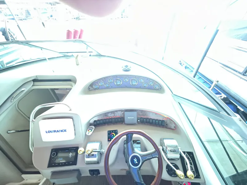 Slide: The Image of 2001 Sea Ray 340 Sundancer helm with steering wheel and navigation instruments. - 13