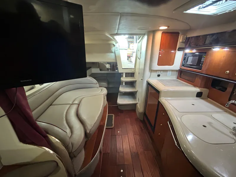 Slide: The Image of Interior of 2001 Sea Ray 340 Sundancer yacht with modern amenities and wood flooring. - 18