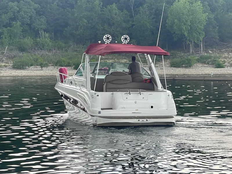 Slide: The Image of 2001 Sea Ray 340 Sundancer boat on calm water with forested shoreline. - 2