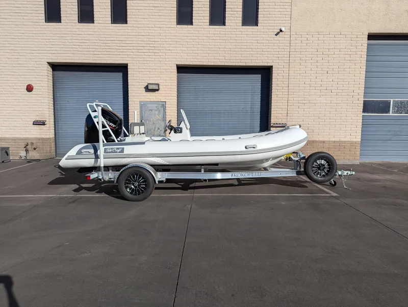 Slide: The Image of 2025 Tide Craft Kodiak 16 boat on trailer, parked outside industrial building. - 10