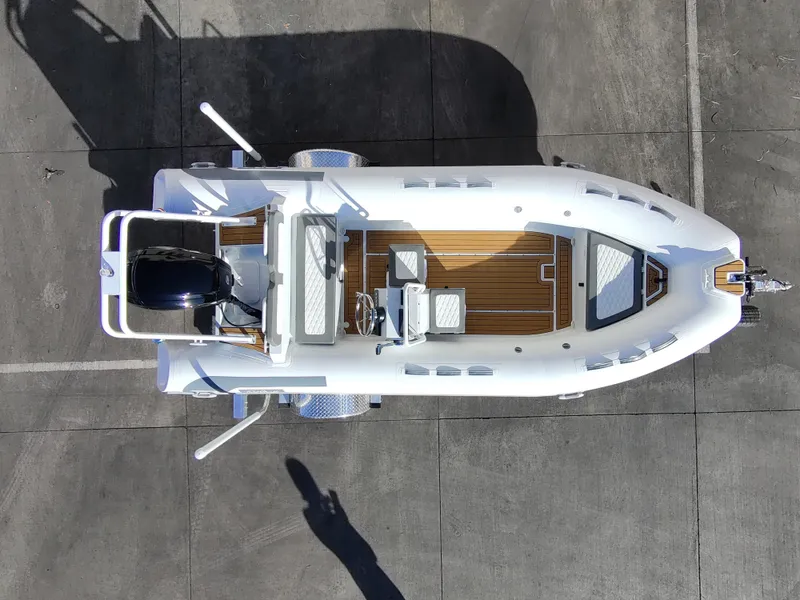 Slide: The Image of 2026 Tide Craft Kodiak 16 boat on a serene lake shore with mountains in the background. - 2