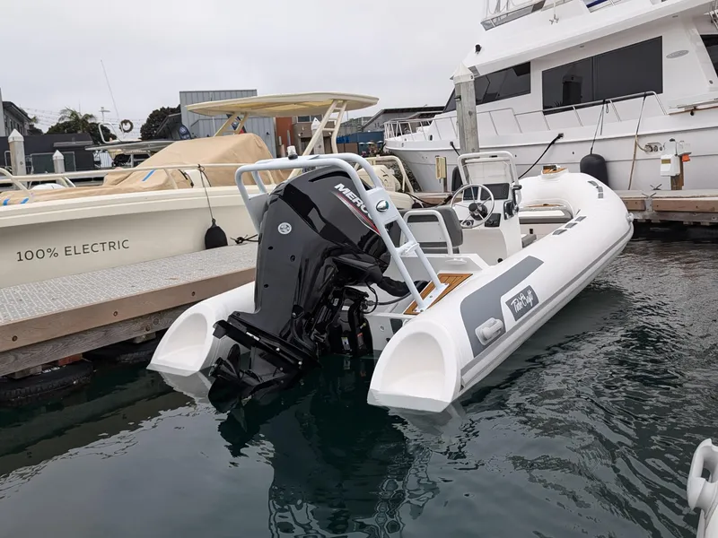 Slide: The Image of 2025 Tide Craft Kodiak 16 boat cruising on calm waters near a marina. - 6