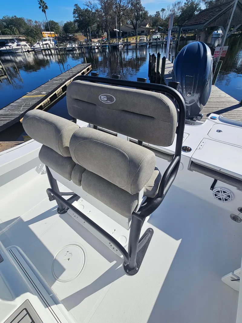 Slide: The Image of 2026 Sea Hunt BX 22 BR boat with cushioned seating, docked by a serene waterfront. - 12