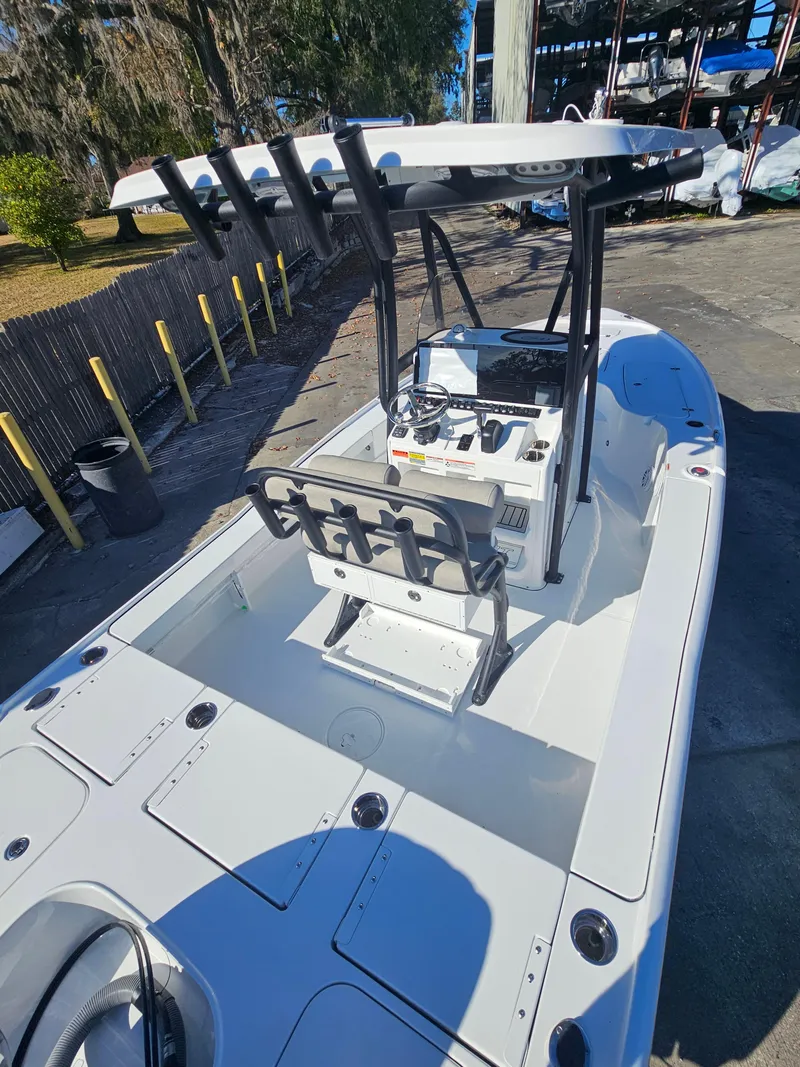 Slide: The Image of 2026 Sea Hunt BX 22 BR boat with center console and rod holders, docked outdoors. - 30