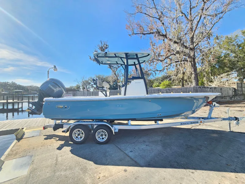 Slide: The Image of 2026 Sea Hunt BX 22 BR boat on trailer, parked near a dock under clear blue sky. - 5
