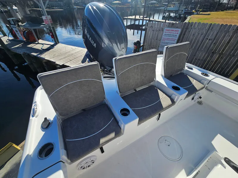 Slide: The Image of 2026 Sea Hunt BX 22 BR boat with three cushioned seats and Yamaha engine at dock. - 9