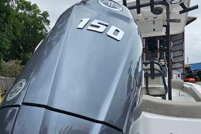 Slide: The Image of 2026 Sea Hunt Ultra 219 boat with a 150 horsepower engine, docked outdoors. - 2
