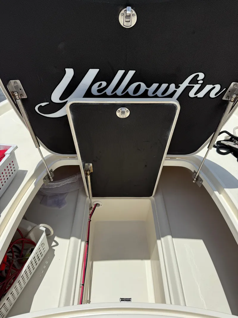 Slide: The Image of 2017 Yellowfin 24 Bay CE boat storage compartment with open hatch and organized interior. - 10