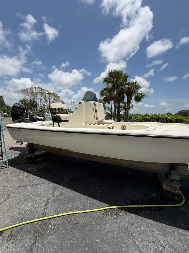 Slide: The Image of 2017 Yellowfin 24 Bay CE boat under a clear blue sky with palm trees. - 2