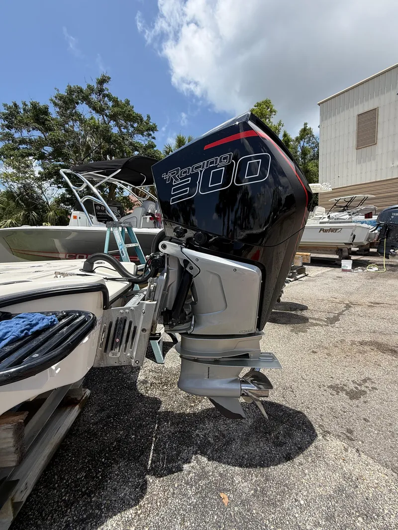 Slide: The Image of 2017 Yellowfin 24 Bay CE boat with a powerful outboard motor, parked outdoors. - 4