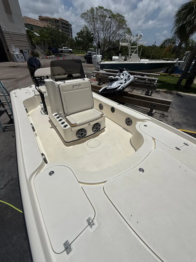 Slide: The Image of 2017 Yellowfin 24 Bay CE boat with spacious deck and seating, docked outdoors. - 8