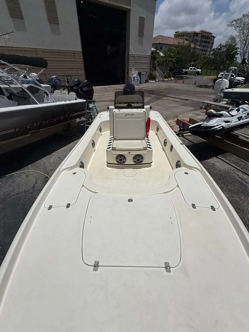 Slide: The Image of 2017 Yellowfin 24 Bay CE boat docked at a marina under a cloudy sky. - 9