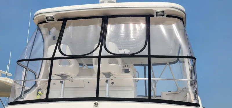 Slide: The Image of 2004 Silverton 48 Convertible yacht with enclosed flybridge against clear blue sky. - 13
