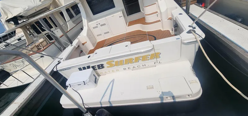 Slide: The Image of 2004 Silverton 48 Convertible yacht docked, featuring spacious deck and elegant design. - 14