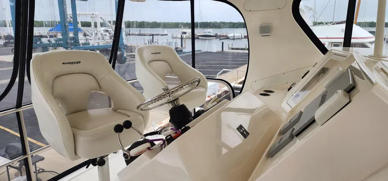 Slide: The Image of 2004 Silverton 48 Convertible yacht helm with dual seats and marina view. - 16