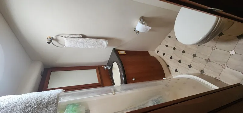 Slide: The Image of Bathroom interior of 2004 Silverton 48 Convertible yacht, featuring sink, toilet, and shower. - 29
