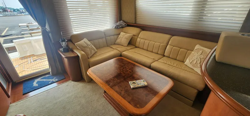 Slide: The Image of Luxurious interior of a 2004 Silverton 48 Convertible yacht with beige seating and wooden table. - 3