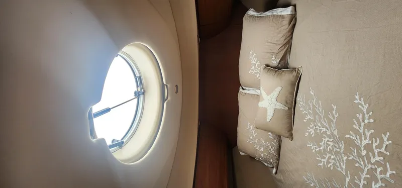 Slide: The Image of Interior cabin of 2004 Silverton 48 Convertible yacht with porthole and decorative pillows. - 30