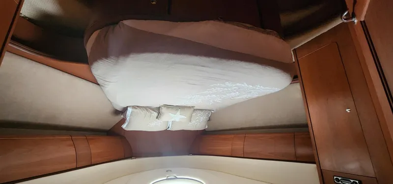 Slide: The Image of Interior cabin of 2004 Silverton 48 Convertible yacht with bed and wooden cabinetry. - 33