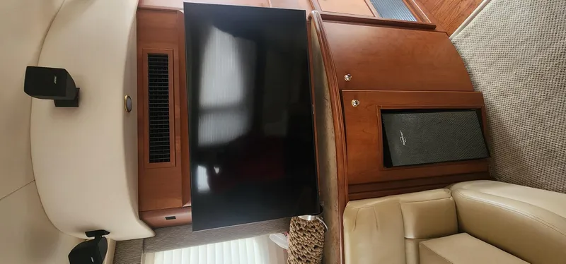 Slide: The Image of Interior of 2004 Silverton 48 Convertible yacht with TV and beige seating. - 35