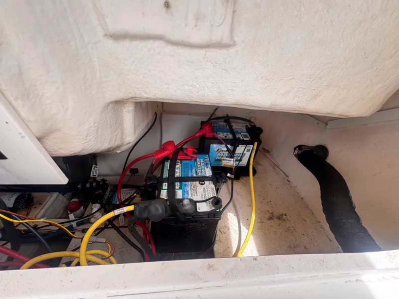 Slide: The Image of 2019 Robalo R227 Dual Console boat battery compartment with wiring and connections. - 24