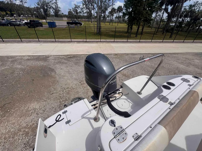 Slide: The Image of 2019 Robalo R227 Dual Console boat with Yamaha 200 engine, parked near a fenced area. - 9